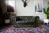 Vintage olive green leather Chesterfield two seater club sofa with deep buttoning and scroll arms