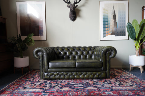 Vintage olive green leather Chesterfield two seater club sofa with deep buttoning and scroll arms