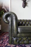 Vintage olive green leather Chesterfield two seater club sofa with deep buttoning and scroll arms