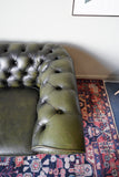 Vintage olive green leather Chesterfield two seater club sofa with deep buttoning and scroll arms