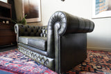Vintage olive green leather Chesterfield two seater club sofa with deep buttoning and scroll arms