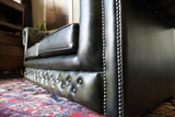 Vintage olive green leather Chesterfield two seater club sofa with deep buttoning and scroll arms