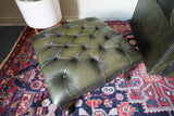 Vintage Chesterfield deep buttoned footstool in antiqued olive green leather with hardwood legs