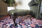 Vintage Chesterfield deep buttoned footstool in antiqued olive green leather with hardwood legs