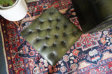 Vintage Chesterfield deep buttoned footstool in antiqued olive green leather with hardwood legs