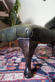 Vintage Chesterfield deep buttoned footstool in antiqued olive green leather with hardwood legs