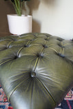 Vintage Chesterfield deep buttoned footstool in antiqued olive green leather with hardwood legs