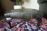 Vintage Chesterfield deep buttoned footstool in antiqued olive green leather with hardwood legs