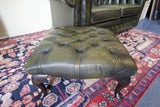 Vintage Chesterfield deep buttoned footstool in antiqued olive green leather with hardwood legs