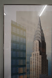 Pair of large framed architectural prints by Richard Davies depicting the Chrysler Building and Empire State Building mounted on wall
