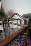 Pair of vintage 1970s bamboo and glass two-tier side tables set on a patterned rug