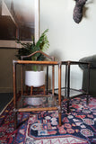 Pair of vintage 1970s bamboo and glass two-tier side tables set on a patterned rug