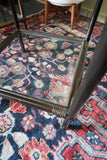 Pair of vintage 1970s bamboo and glass two-tier side tables set on a patterned rug