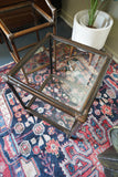 Pair of vintage 1970s bamboo and glass two-tier side tables set on a patterned rug